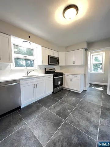 a kitchen with a sink window and cabinets