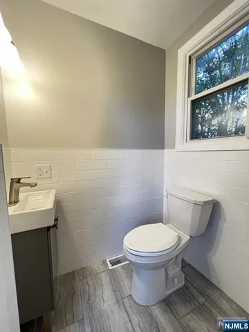 a bathroom with a toilet a sink and mirror