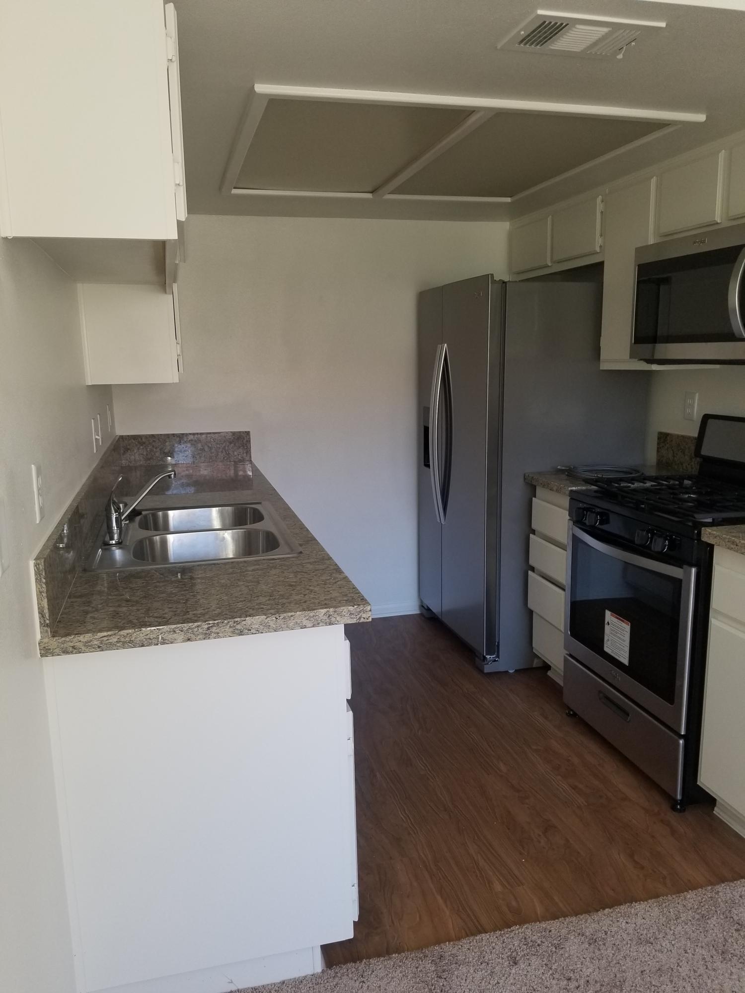 43487 30th Street West, Unit 2 Lancaster, CA 93536 - Photo 7 of 16 a kitchen with granite countertop a sink and a stove