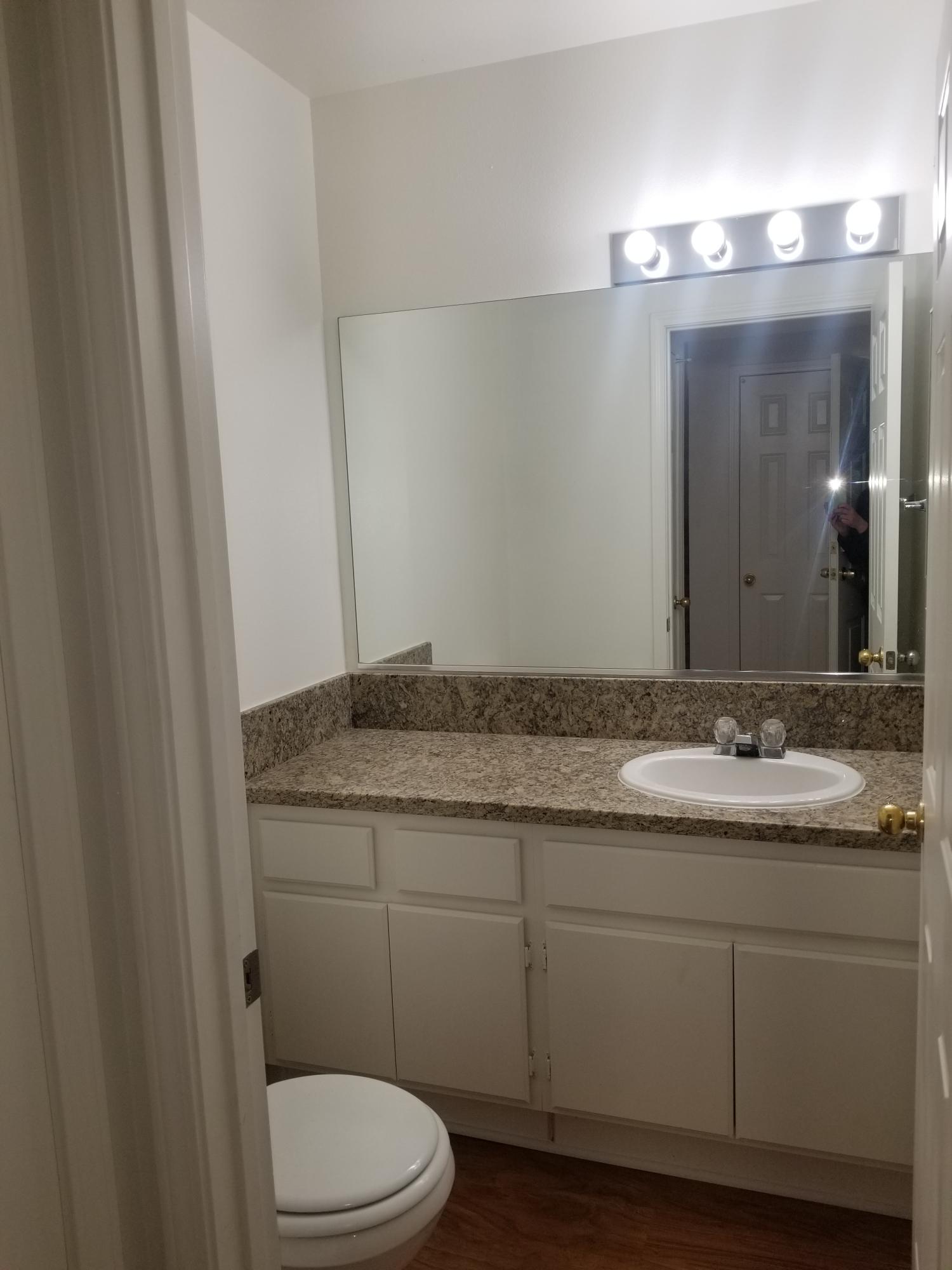 43487 30th Street West, Unit 2 Lancaster, CA 93536 - Photo 8 of 16 a bathroom with a granite countertop toilet sink and mirror