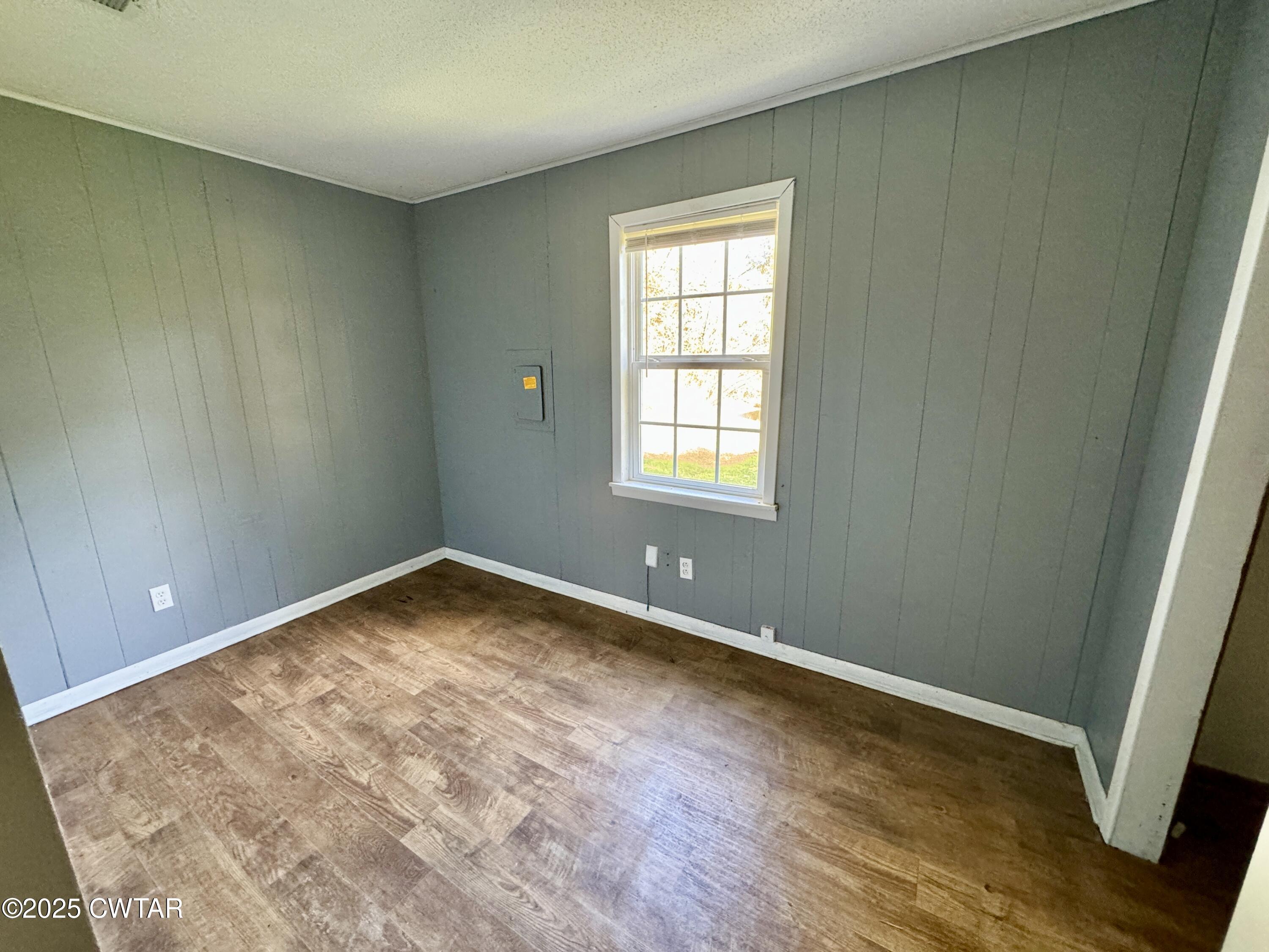 808 Barlow Road Ripley, TN 38063 - Photo 6 of 13 an empty room with wooden floor and windows