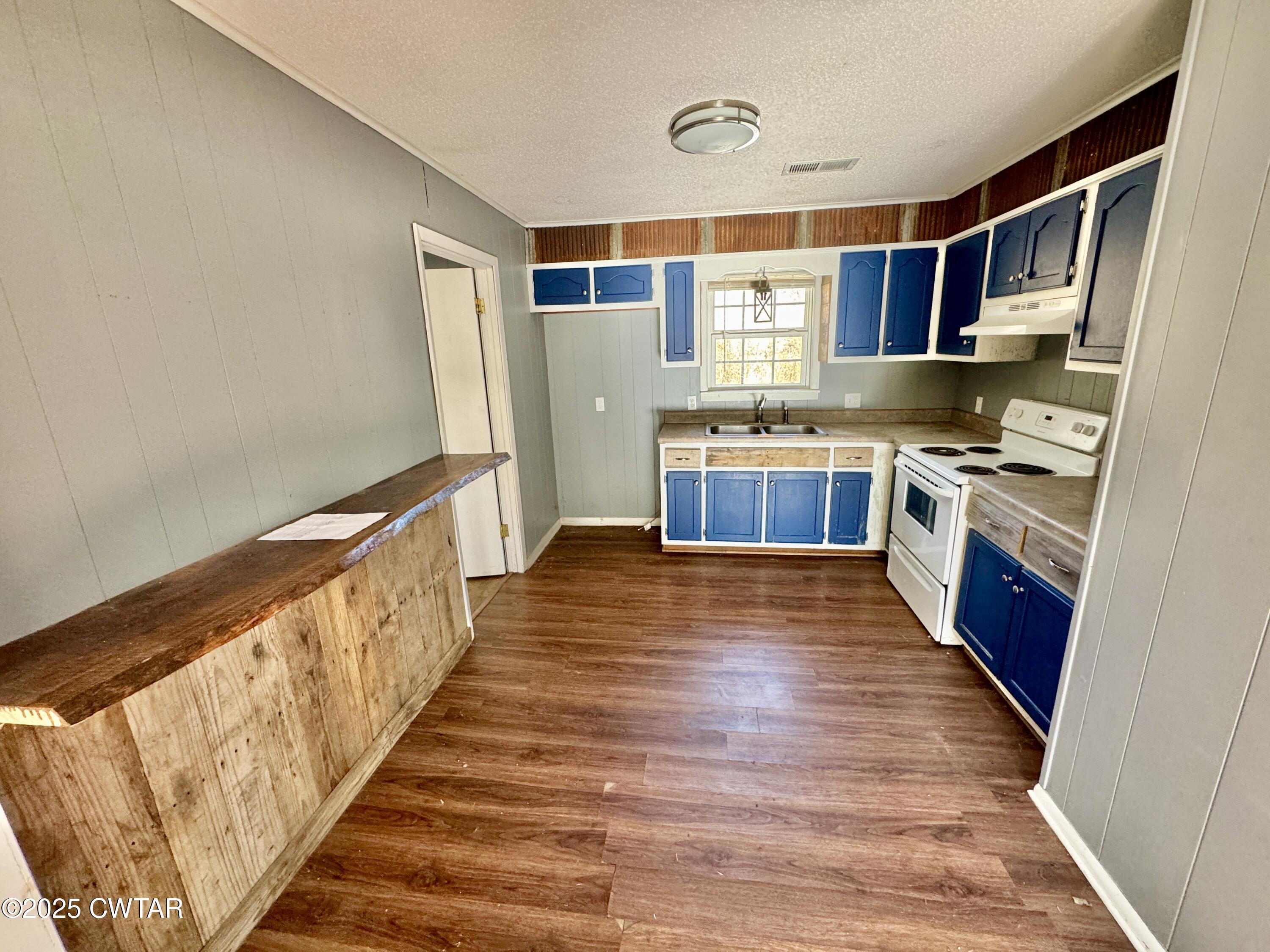 808 Barlow Road Ripley, TN 38063 - Photo 9 of 13 a large kitchen with cabinets wooden floor and stainless steel appliances