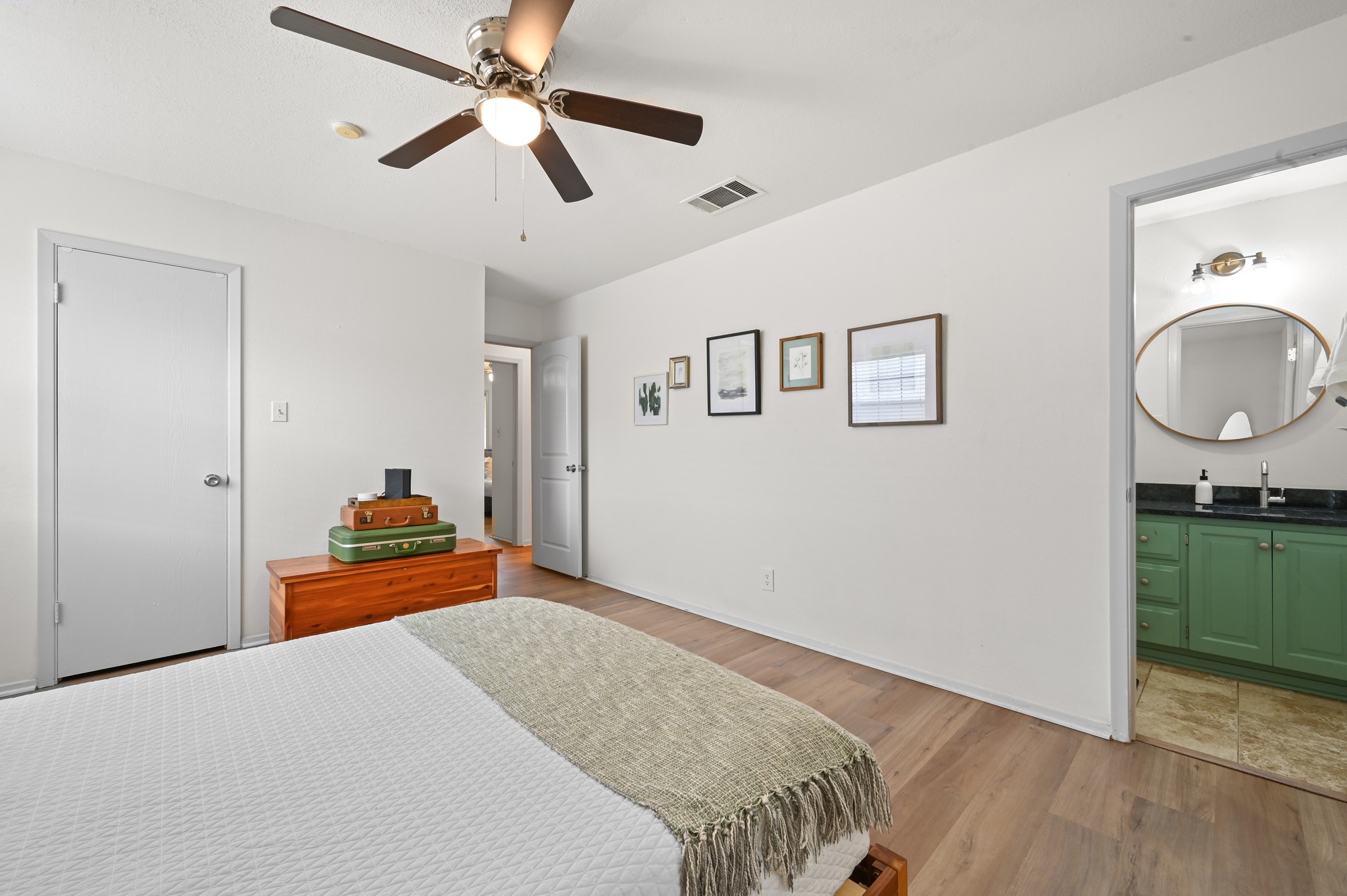 6805 Rearden Road Austin, TX 78745 - Photo 14 of 26 Hardwood-style flooring extends into this spacious bedroom, offering seamless flow and a welcoming ambiance.