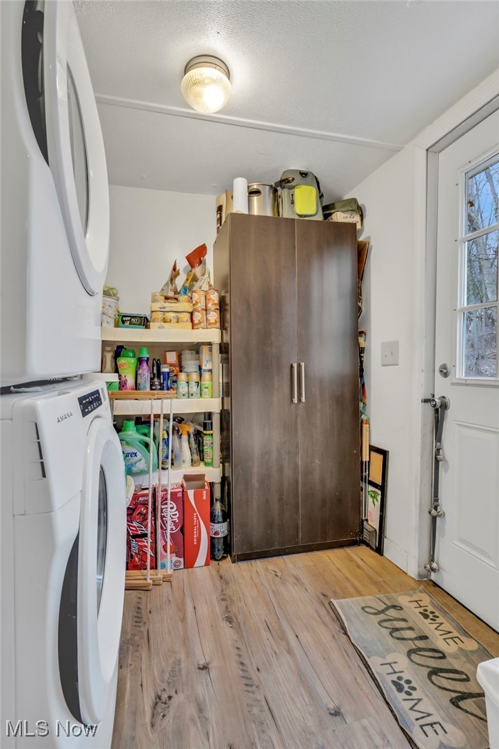 2131 Gordon Road Northwest Dover, OH 44622 - Photo 5 of 25 Laundry room featuring stacked washer and clothes dryer and wood-type flooring