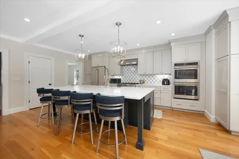 a kitchen with stainless steel appliances granite countertop a stove a sink a microwave a dining table and chairs