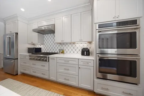 a kitchen with cabinets stainless steel appliances and a counter space