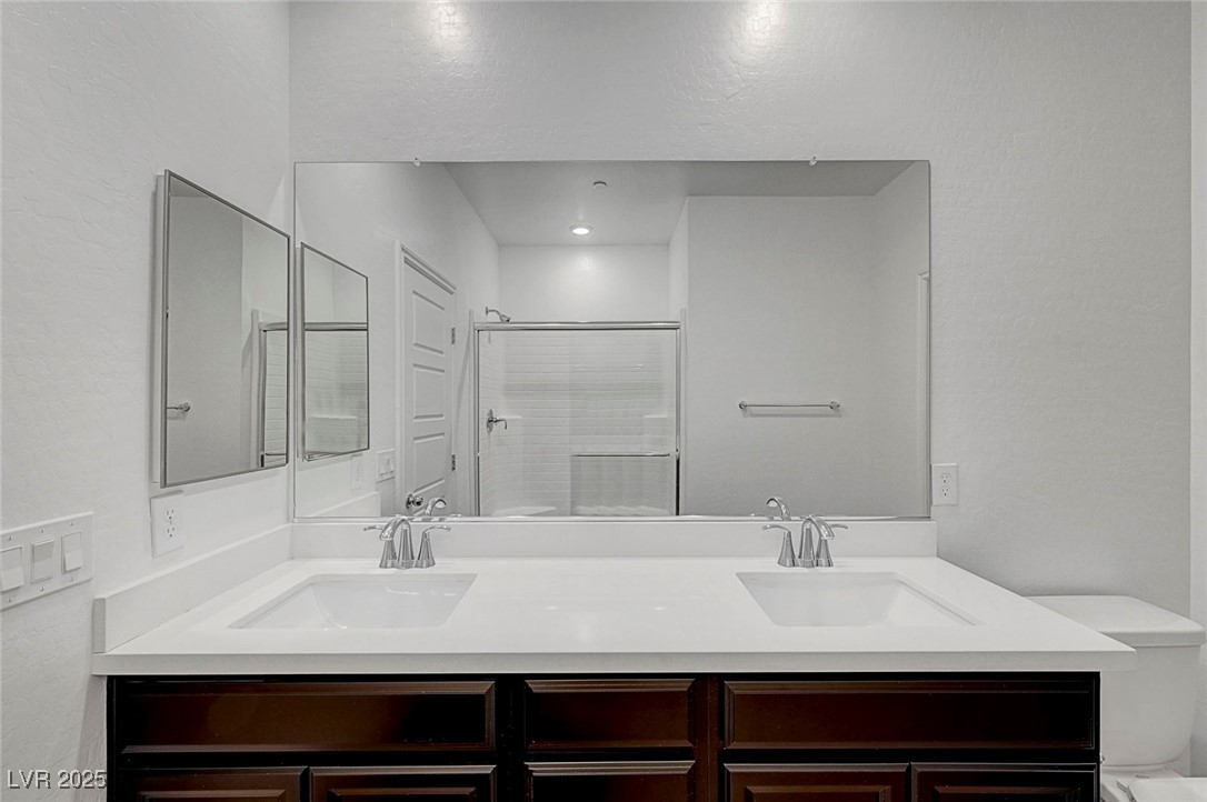 7204 North Decatur Boulevard North Las Vegas, NV 89084 - Photo 37 of 55 Full bath featuring a shower with door, double vanity, a sink, and toilet