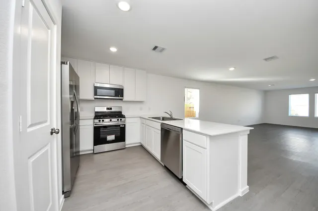 a kitchen with a refrigerator a stove top oven a sink and dishwasher