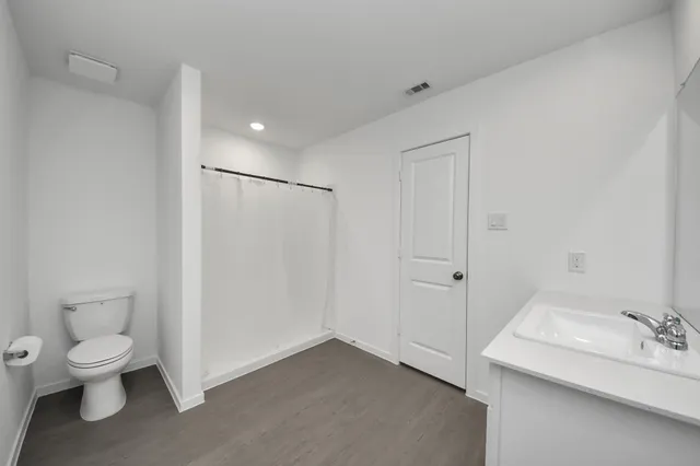 a bathroom with a sink a toilet and shower