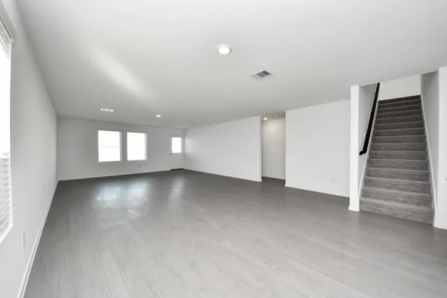 a view of a kitchen with white cabinets and wooden floor