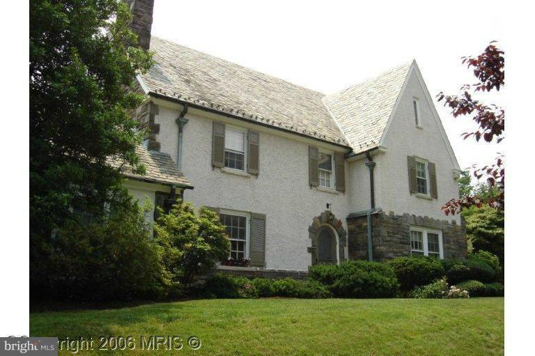 a view of a house with brick walls and a yard with plants