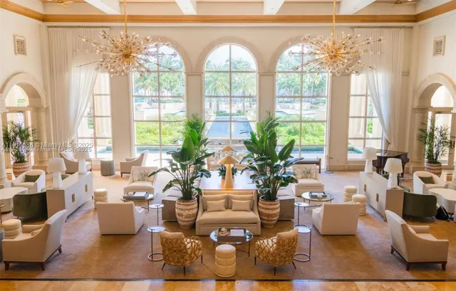 a living room with patio furniture and floor to ceiling windows