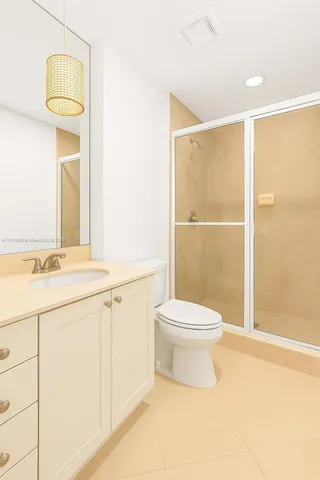 a bathroom with a toilet a sink a shower and a mirror
