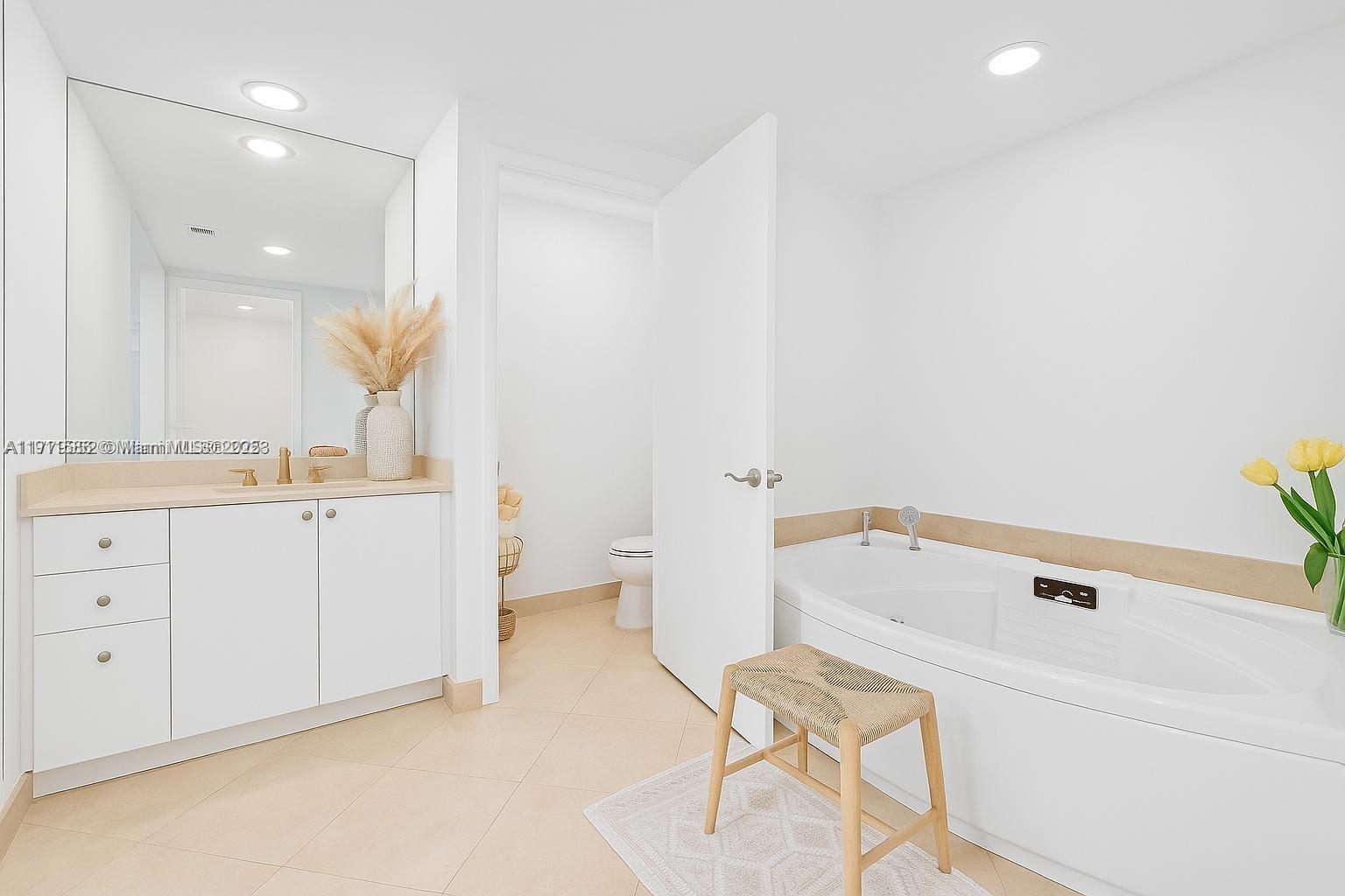 781 Crandon Boulevard, Unit 106 Key Biscayne, FL 33149 - Photo 8 of 20 a bathroom with a tub sink and a mirror