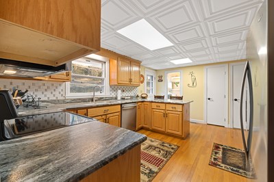 1654 Myers Chapel Road Hayesville, NC 28904 - Photo 12 of 60 a kitchen with stainless steel appliances granite countertop a sink and wooden cabinets