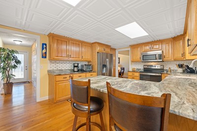 1654 Myers Chapel Road Hayesville, NC 28904 - Photo 14 of 60 a kitchen with stainless steel appliances granite countertop a stove a refrigerator a sink dishwasher a dining table and chairs with wooden floor