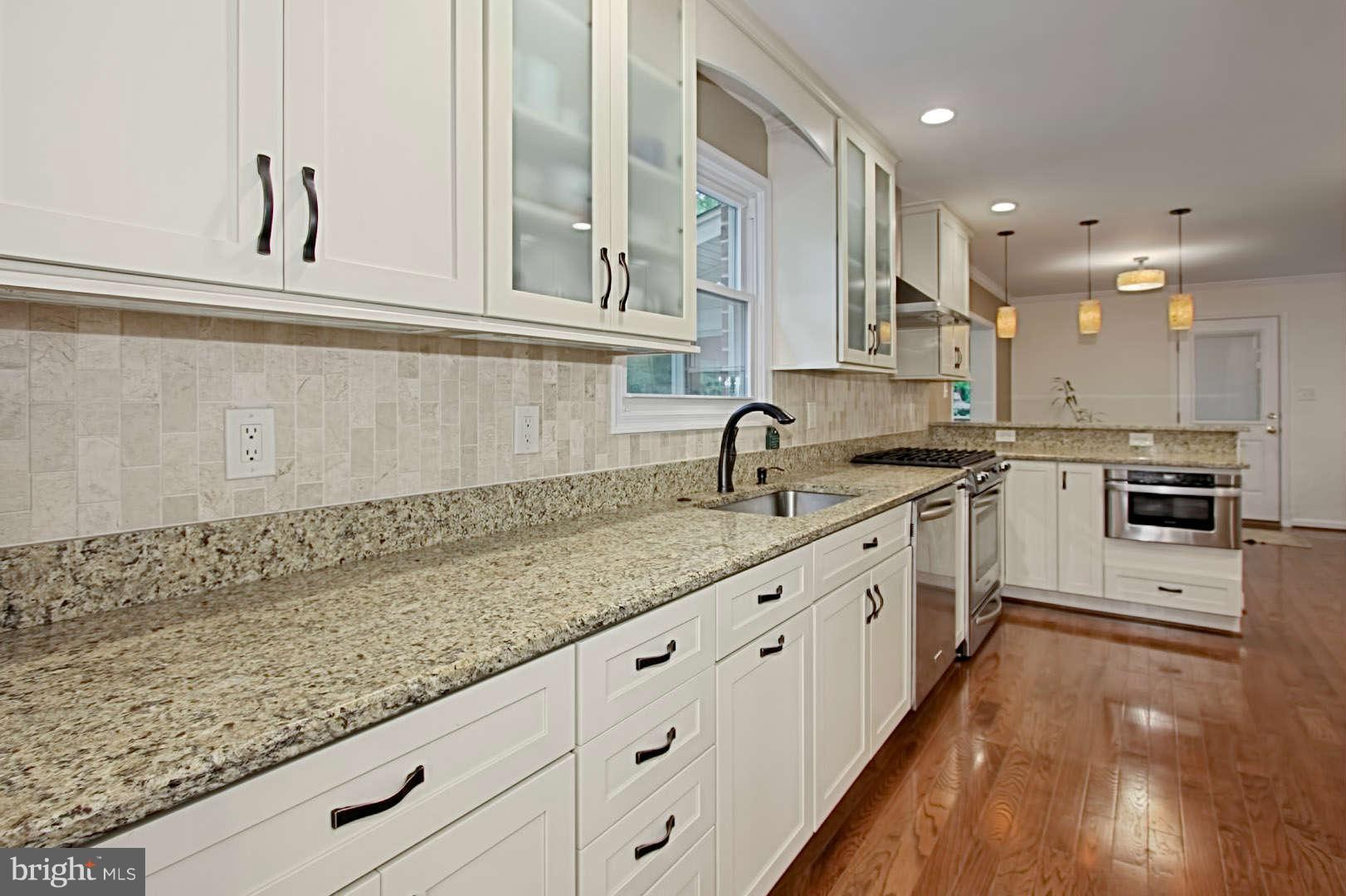 7006 Spaniel Road Springfield, VA 22153 - Photo 8 of 29 a kitchen with granite countertop white cabinets and white appliances