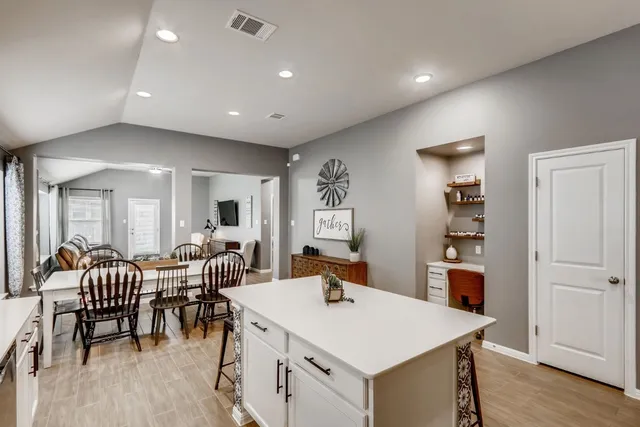 a large white kitchen with a table and chairs