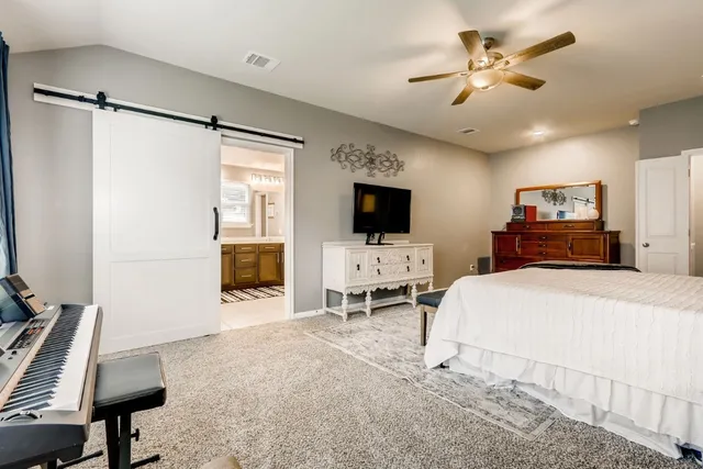 a bedroom with a bed window and a flat screen tv