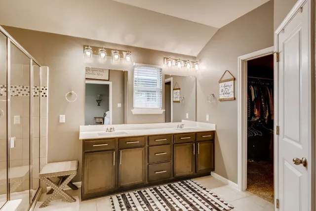a spacious bathroom with a shower a sink and a mirror