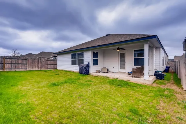a view of a house with backyard and porch