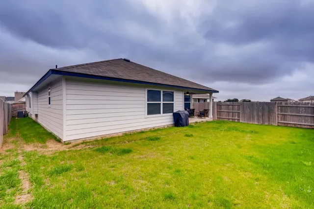 a backyard of a house with table and chairs