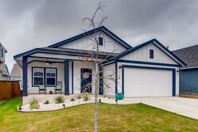 a front view of a house with a yard outdoor seating and garage