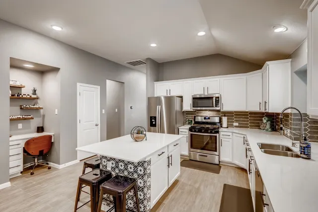 a kitchen with a sink a counter top space stainless steel appliances and cabinets