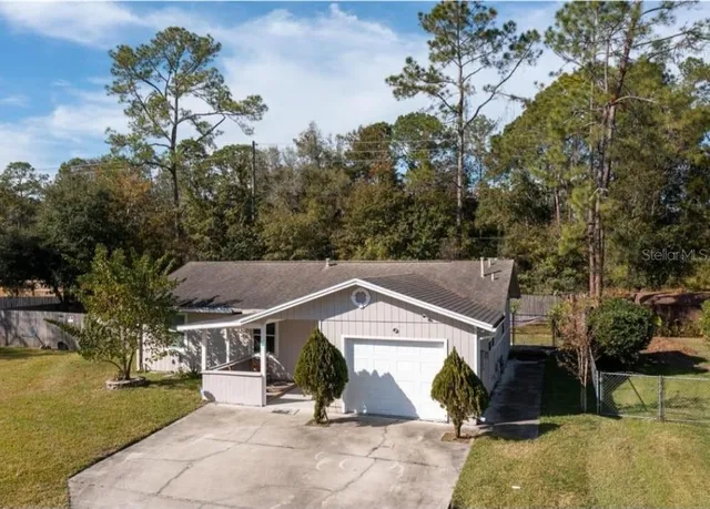 an aerial view of a house with swimming pool and garden