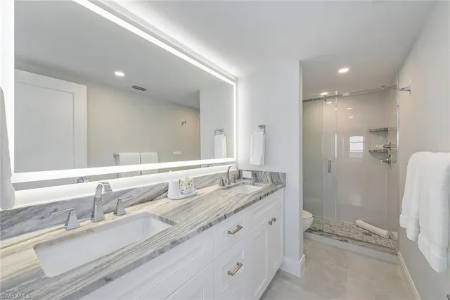 a bathroom with a double vanity sink mirror double and shower