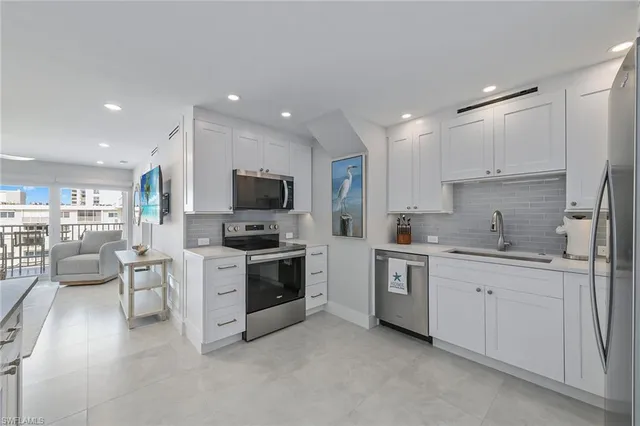a kitchen with white cabinets and stainless steel appliances