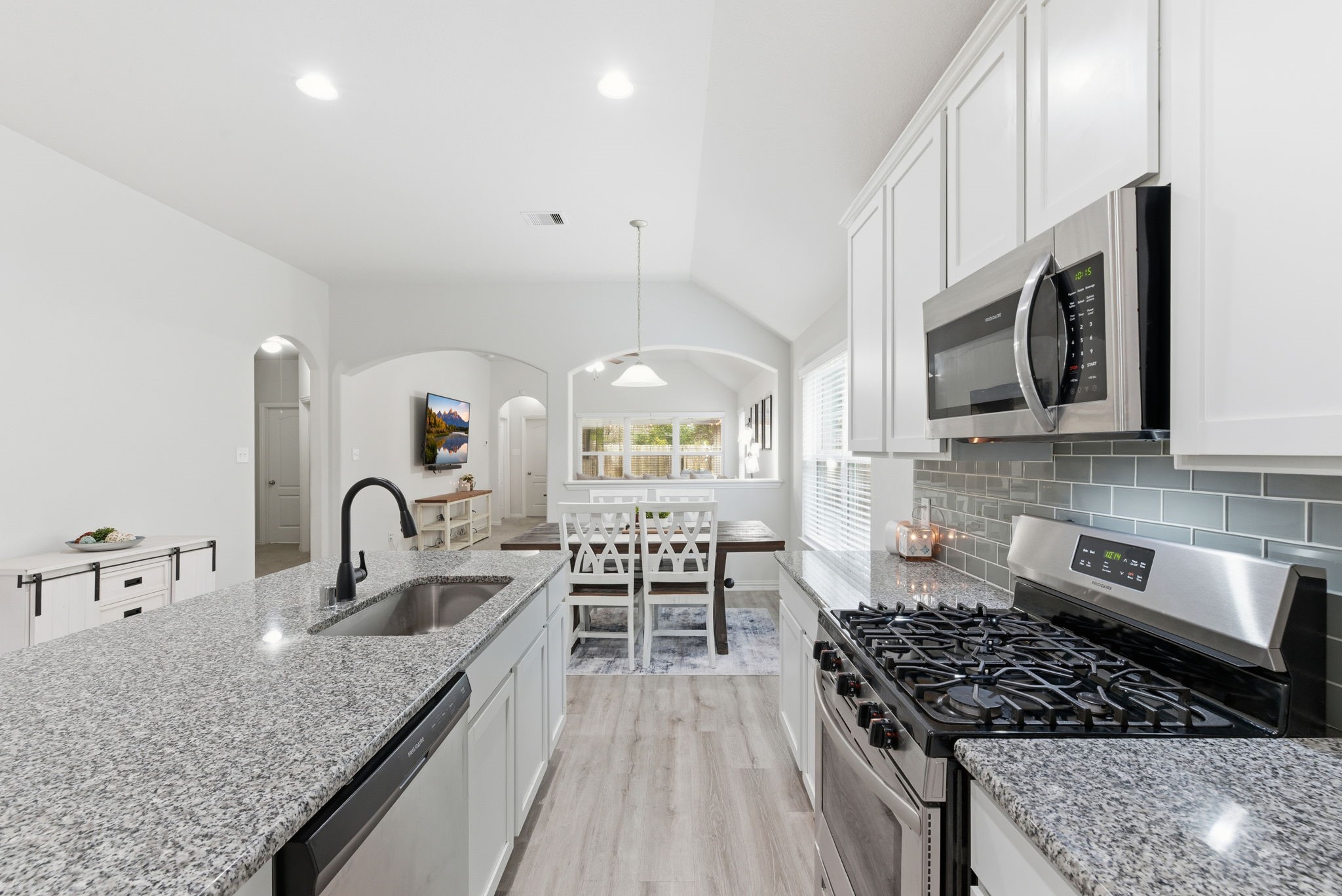 27146 Grey Fox Run Magnolia, TX 77354 - Photo 13 of 44 a kitchen with granite countertop a stove a sink and a microwave