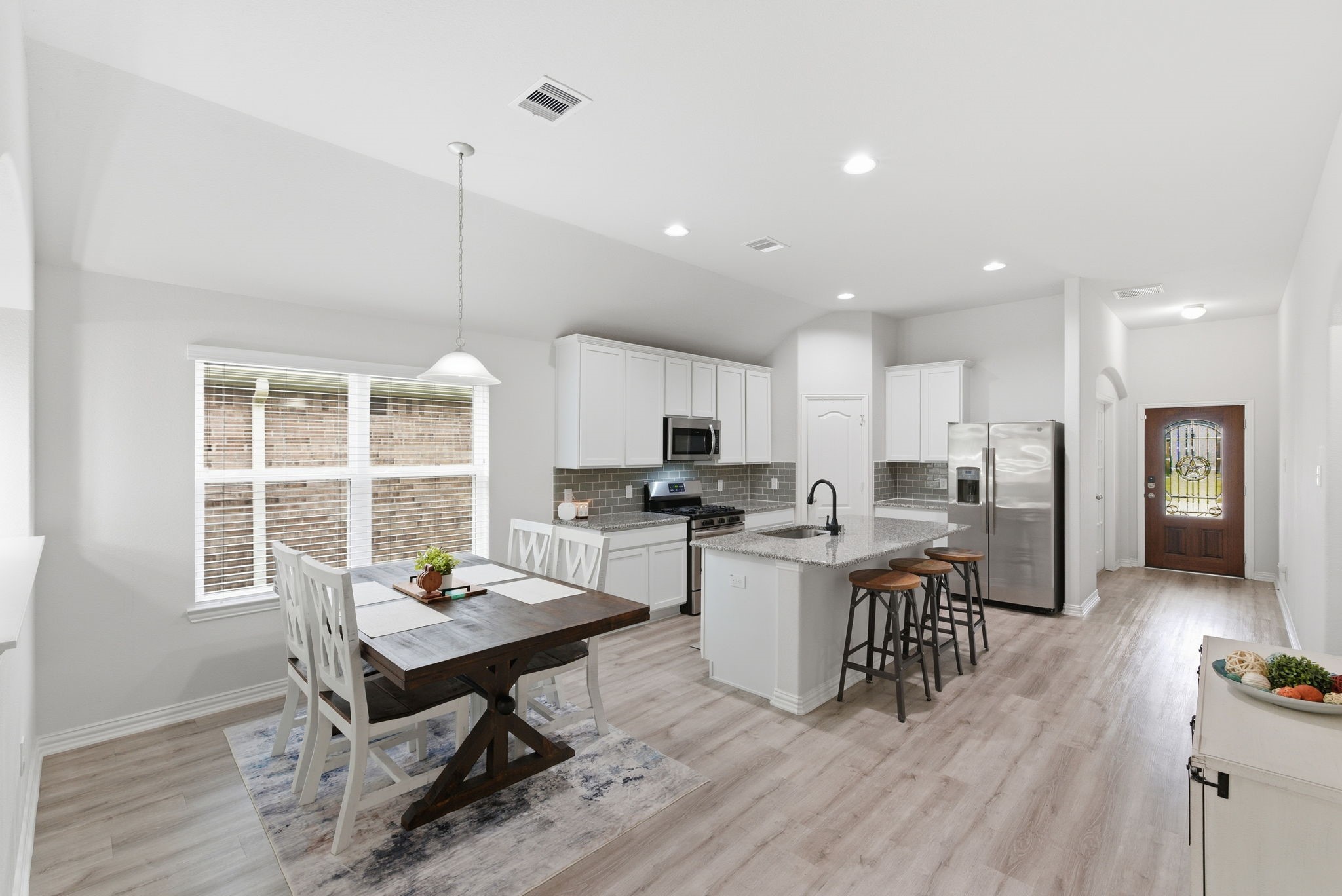 27146 Grey Fox Run Magnolia, TX 77354 - Photo 10 of 44 a kitchen with a table chairs wooden floors and a view of living room