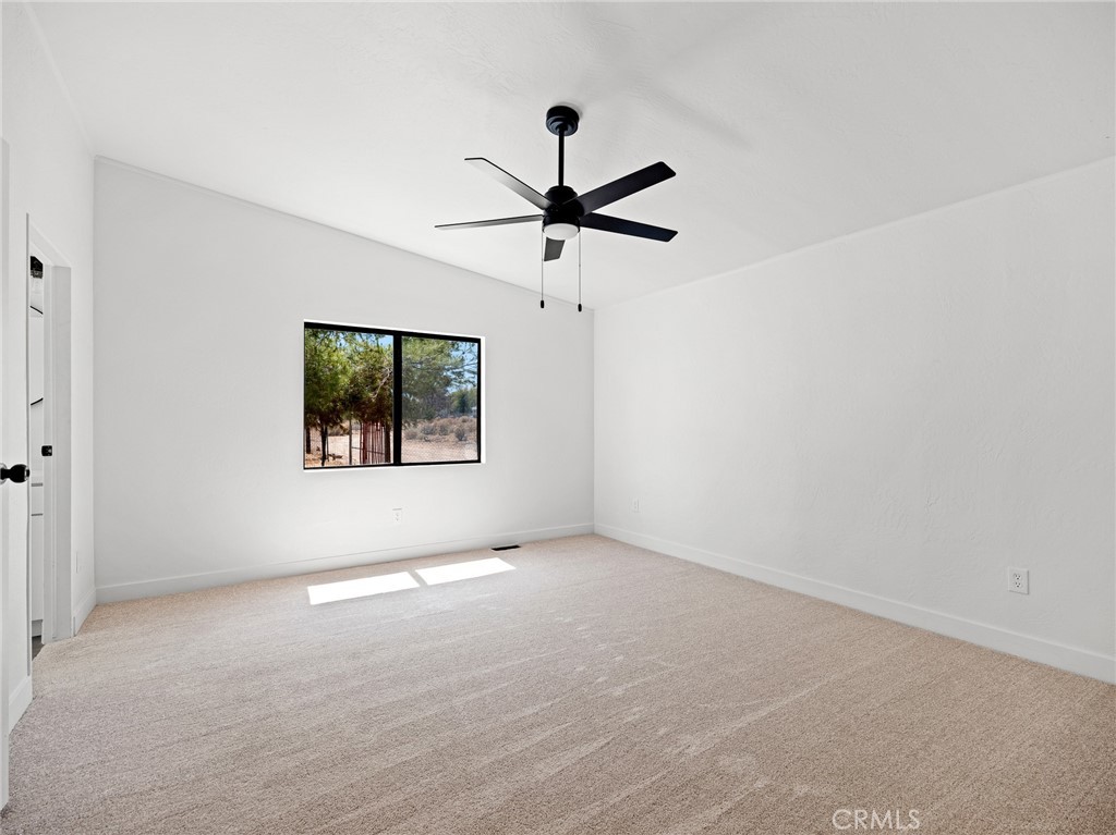 10139 Sonora Road Phelan, CA 92371 - Photo 21 of 37 en empty room with window and ceiling fan