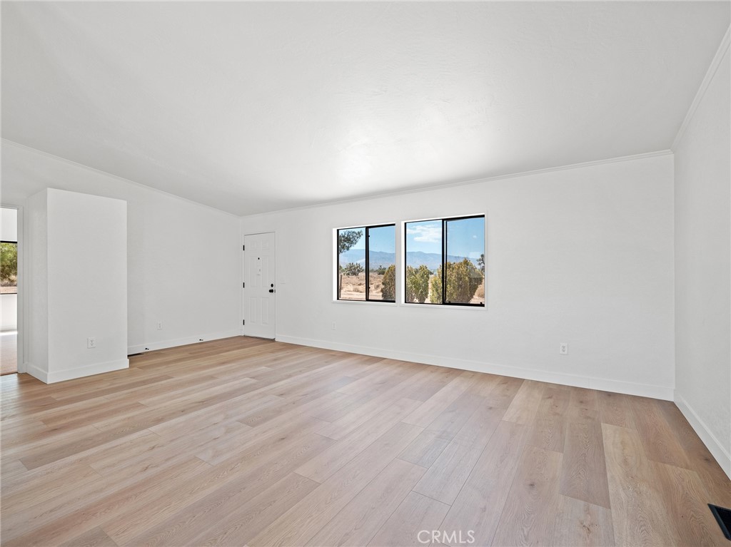 10139 Sonora Road Phelan, CA 92371 - Photo 5 of 37 an empty room with wooden floor and windows