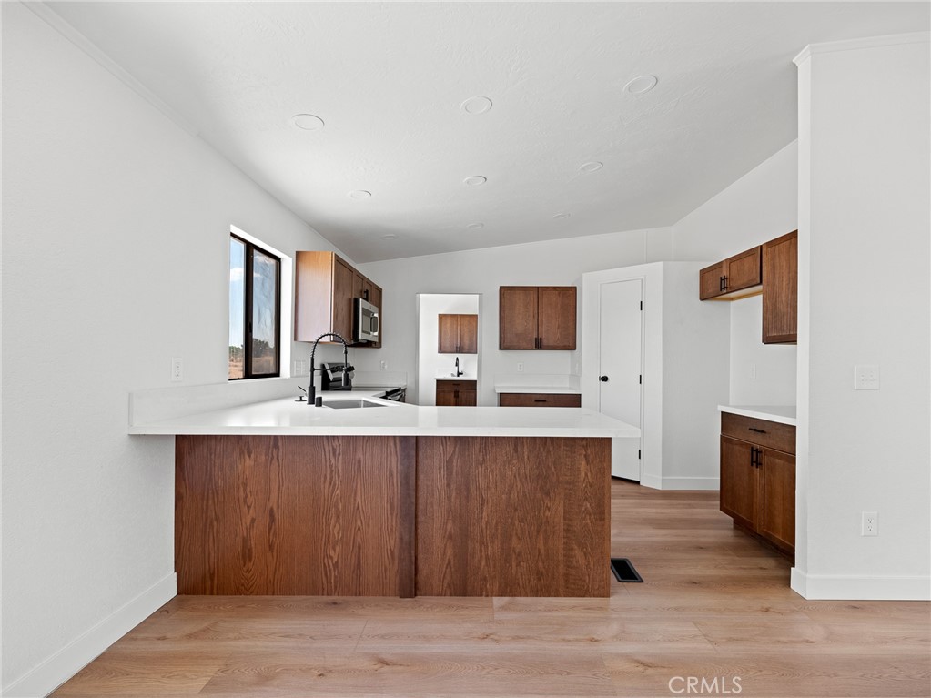 10139 Sonora Road Phelan, CA 92371 - Photo 7 of 37 a large kitchen with cabinets wooden floor and stainless steel appliances