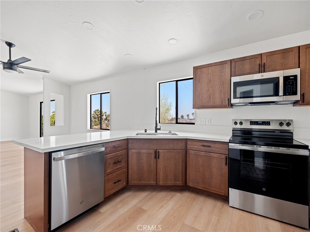 10139 Sonora Road Phelan, CA 92371 - Photo 8 of 37 a kitchen with stainless steel appliances granite countertop a stove top oven a sink and cabinets
