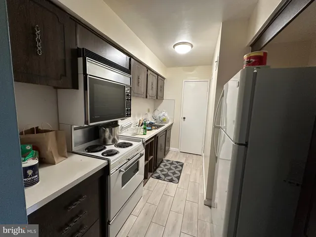 a kitchen with stainless steel appliances a refrigerator a stove a sink and a refrigerator