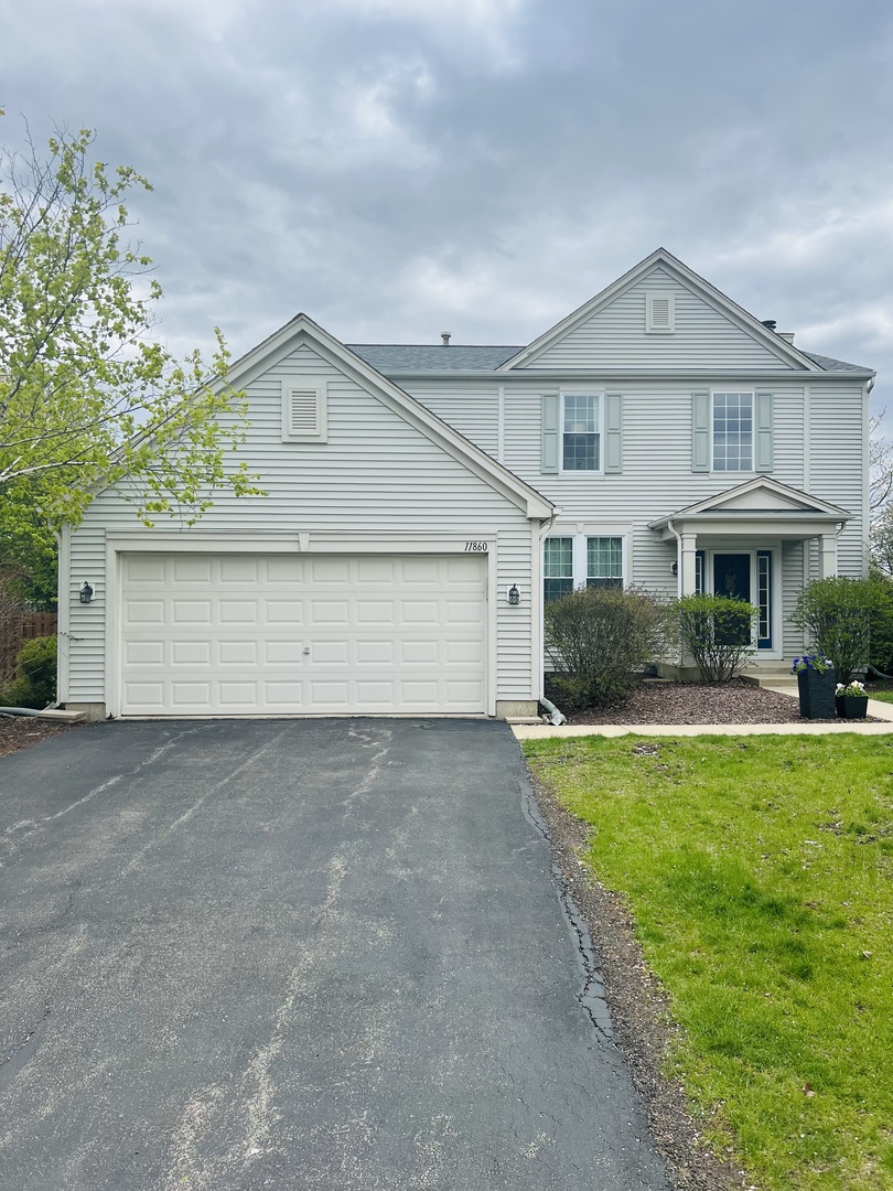 11860 Presley Circle Plainfield, IL 60585 - Photo 2 of 18 a front view of a house with a yard and garage