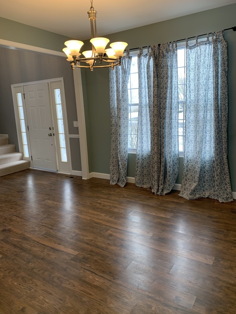 11860 Presley Circle Plainfield, IL 60585 - Photo 3 of 18 an empty room with wooden floor and windows