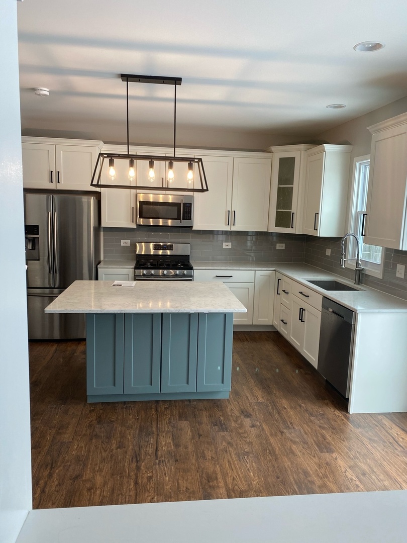 11860 Presley Circle Plainfield, IL 60585 - Photo 5 of 18 a kitchen with kitchen island granite countertop a sink cabinets and stainless steel appliances