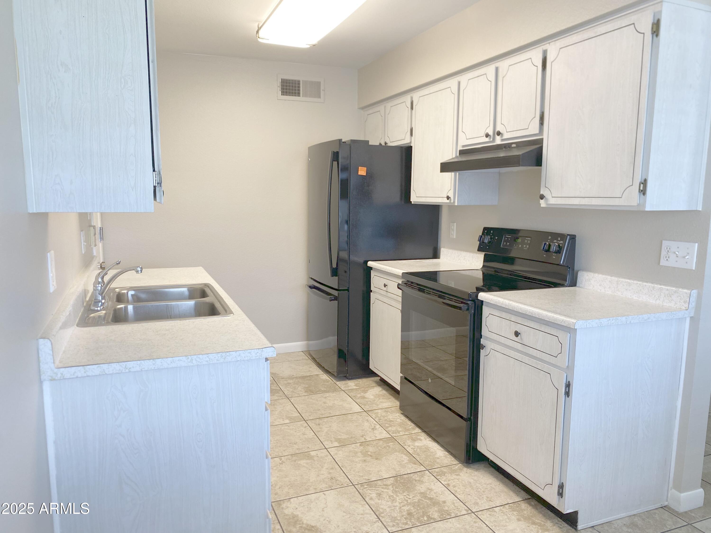 10417 North 95th Drive, Unit B Peoria, AZ 85345 - Photo 2 of 18 a kitchen with a sink a stove and refrigerator