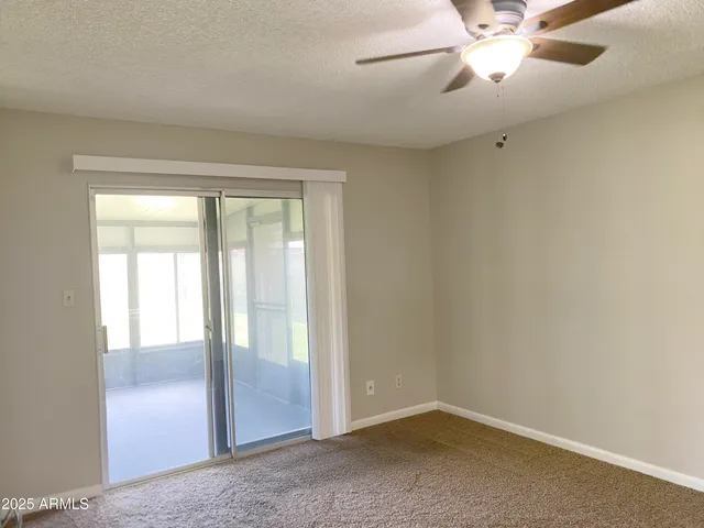 an empty room with closet and a chandelier fan