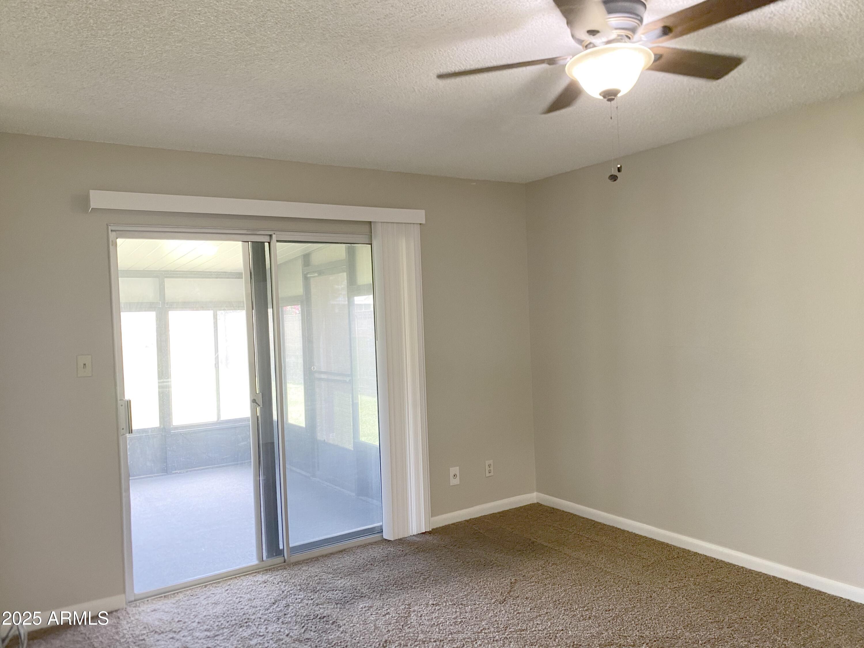 10417 North 95th Drive, Unit B Peoria, AZ 85345 - Photo 5 of 18 an empty room with closet and a chandelier fan