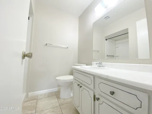 a bathroom with a toilet a sink a vanity and mirror