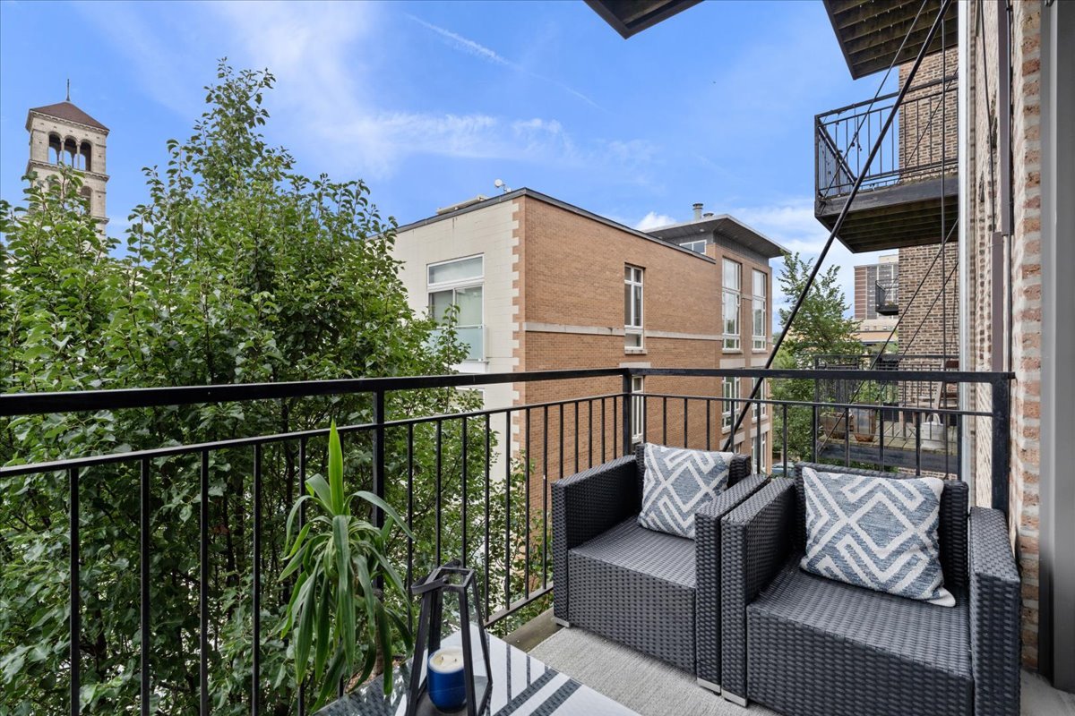 4144 North Sheridan Road, Unit 407 Chicago, IL 60613 - Photo 15 of 19 a balcony with wooden floor and outdoor seating