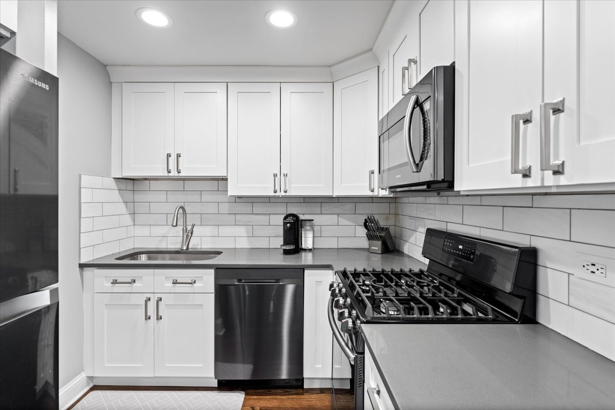 4144 North Sheridan Road, Unit 407 Chicago, IL 60613 - Photo 9 of 19 a kitchen with stainless steel appliances granite countertop a stove a sink and a refrigerator