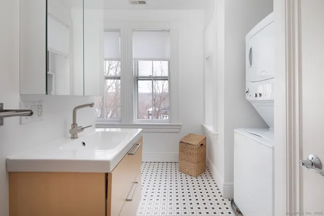 a bathroom with a sink a toilet and a window