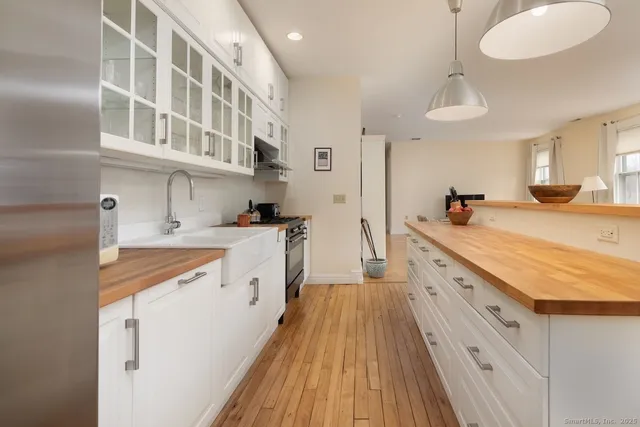 a large kitchen with a lot of counter space and wooden floor