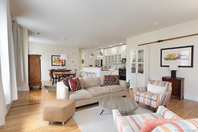 a living room with furniture and a view of kitchen